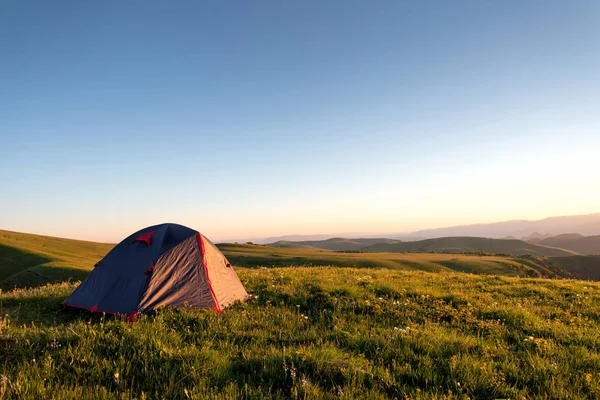 観光テントは 山の背景に午前中に緑の草の上に立っています — ストック写真