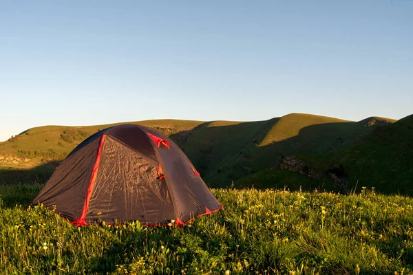 観光テントは 山の背景に午前中に緑の草の上に立っています — ストック写真