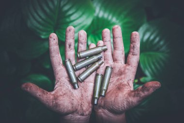 yeşil yaprakları bir arka plan karşı kirli çocukların elinde boş atış mühimmat ve tüm mühimmat