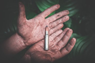 yeşil yaprakların bir arka plan kirli çocuk elinde bir bütün mühimmat