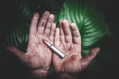 yeşil yaprakların bir arka plan kirli çocuk elinde bir bütün mühimmat