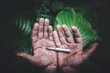 yeşil yaprakların bir arka plan kirli çocuk elinde bir bütün mühimmat