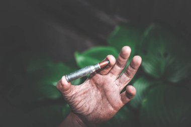 yeşil yaprakların bir arka plan kirli çocuk elinde bir bütün mühimmat