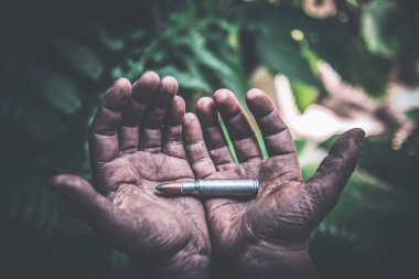 yeşil yaprakların bir arka plan kirli çocuk elinde bir bütün mühimmat