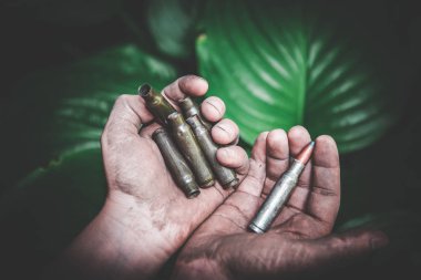 yeşil yaprakları bir arka plan karşı kirli çocukların elinde boş atış mühimmat ve tüm mühimmat