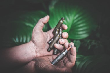 yeşil yaprakları bir arka plan karşı kirli çocukların elinde boş atış mühimmat ve tüm mühimmat