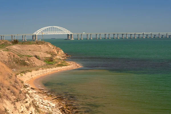 Crimean bridge next to the sandy beach on the sea