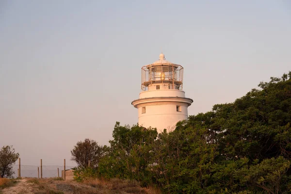 Karadeniz'de Kırım'da yeşil ağaçlarla çevrili beyaz deniz feneri