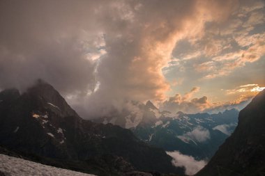 # Gün batımında mavi gökyüzü # # Dağların tepelerinde büyük pembe bulutlar #