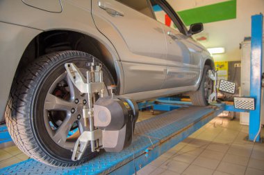 Bir araba servisinde tekerlek hizalayıcısı bir araba tekerleğine monte edildi