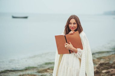 Hayatını kendin yarat! Denizdeki güzel, düşünceli, hayalperest kadın, romantik ruh hali, düşünme tarzı, tatil, kitap tutmak, günlüğe notlar yazmak. Yalnızlık, ilham, fikirler, hedefler..