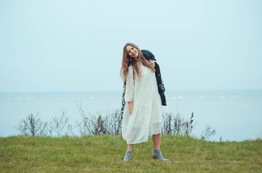 Beyaz elbiseli, düşünceli, hayalperest kadın dağın zirvesine ulaşıyor ve rüzgarın tadını çıkarıyor. Başarılı bir kadın hayatı rahatlatıyor. İlham, yalnızlık, uyum kavramı. Kadın enerjisi ve hedefi.