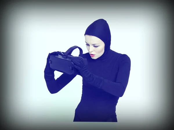 VR-kuulokkeita tarkastava nainen — kuvapankkivalokuva