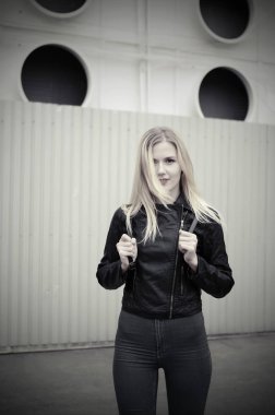 Kadın bir siyah ceket ve kot şehirde poz