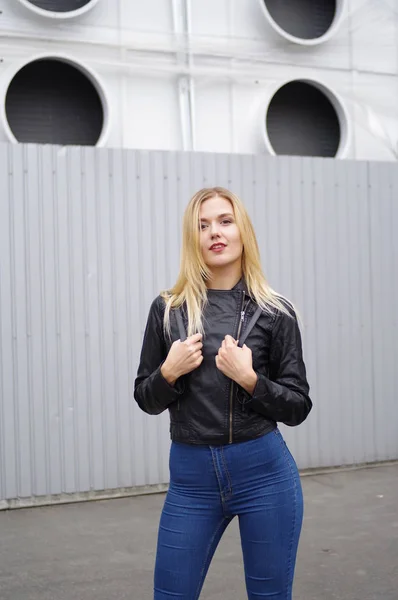 Mulher de casaco preto e jeans posando na cidade — Fotografia de Stock