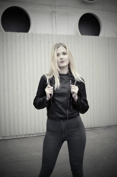 Mujer con chaqueta negra y jeans posando en la ciudad —  Fotos de Stock