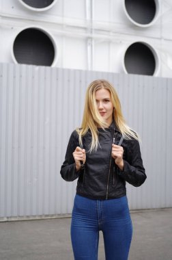 Kadın bir siyah ceket ve kot şehirde poz