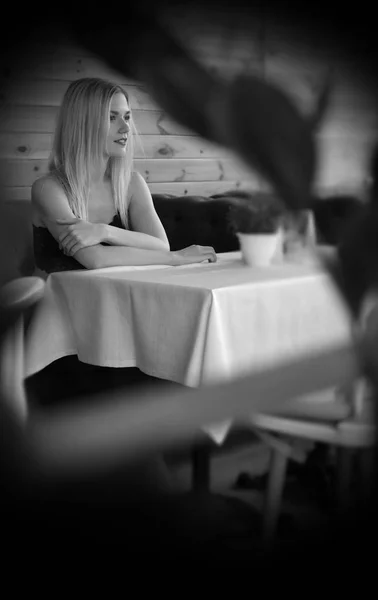 Une belle jeune femme assise sur un canapé violet dans un café — Photo