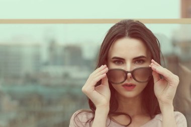 Genç bir uzun saçlı esmer kadın güneş gözlüğü ile çalış