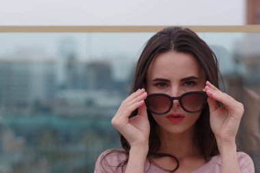 Genç bir uzun saçlı esmer kadın güneş gözlüğü ile çalış