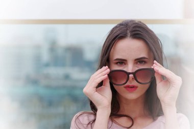 Genç bir uzun saçlı esmer kadın güneş gözlüğü ile çalış