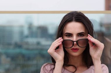 Genç bir uzun saçlı esmer kadın güneş gözlüğü ile çalış