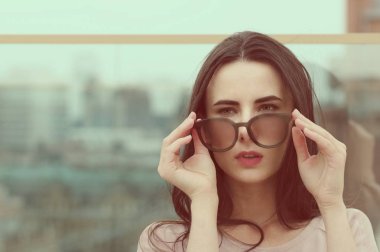 Genç bir uzun saçlı esmer kadın güneş gözlüğü ile çalış