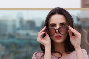 Genç bir uzun saçlı esmer kadın güneş gözlüğü ile çalış