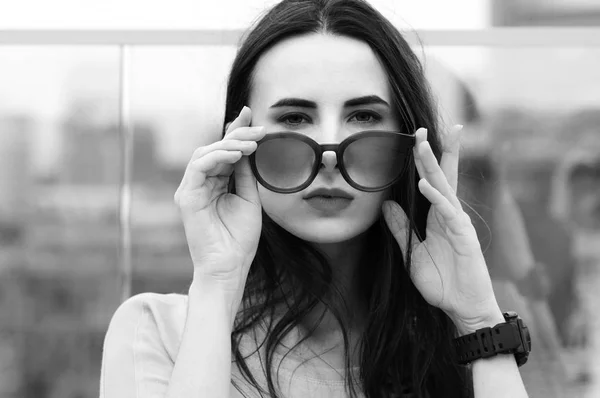 Брюнетка жінка грає з сонцезахисні окуляри — стокове фото