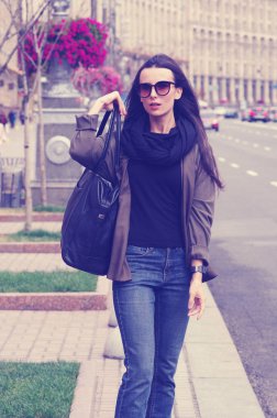 Siyah saçlı bir kız açık havada Jeans