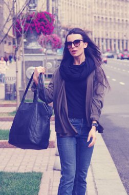 Siyah saçlı bir kız açık havada Jeans