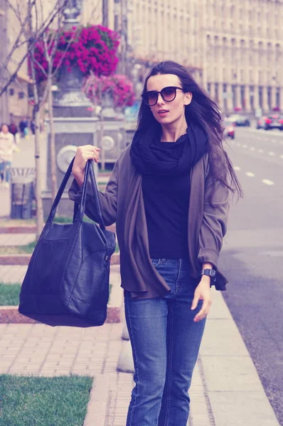 Siyah saçlı bir kız açık havada Jeans