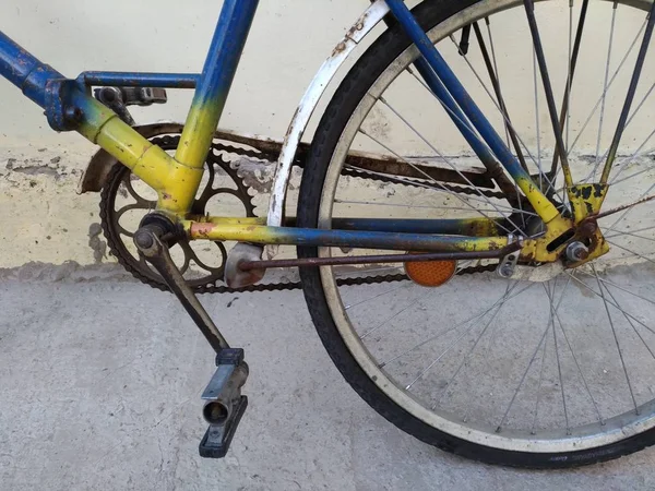 Fragmento de uma bicicleta velha pintada em amarelo, azul — Fotografia de Stock