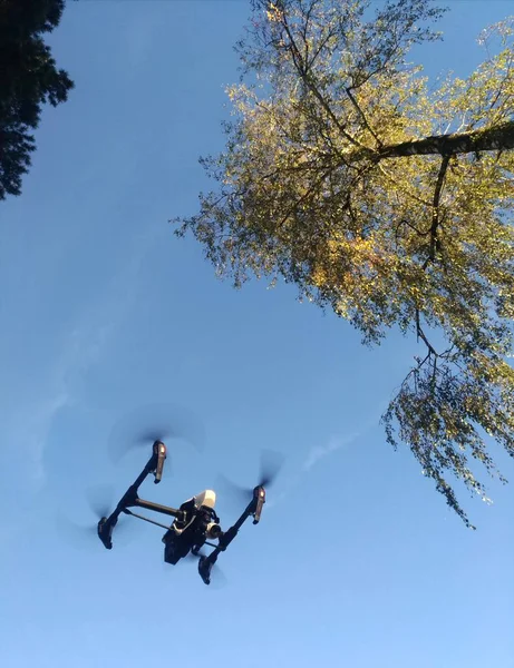 Kopter drone repül a kék ég, propellerek forgatás — Stock Fotó