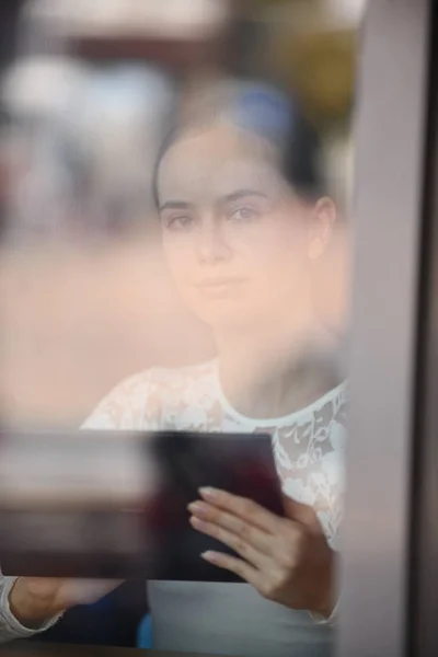 Mujer joven trabajando, comunicándose con la tableta — Foto de Stock