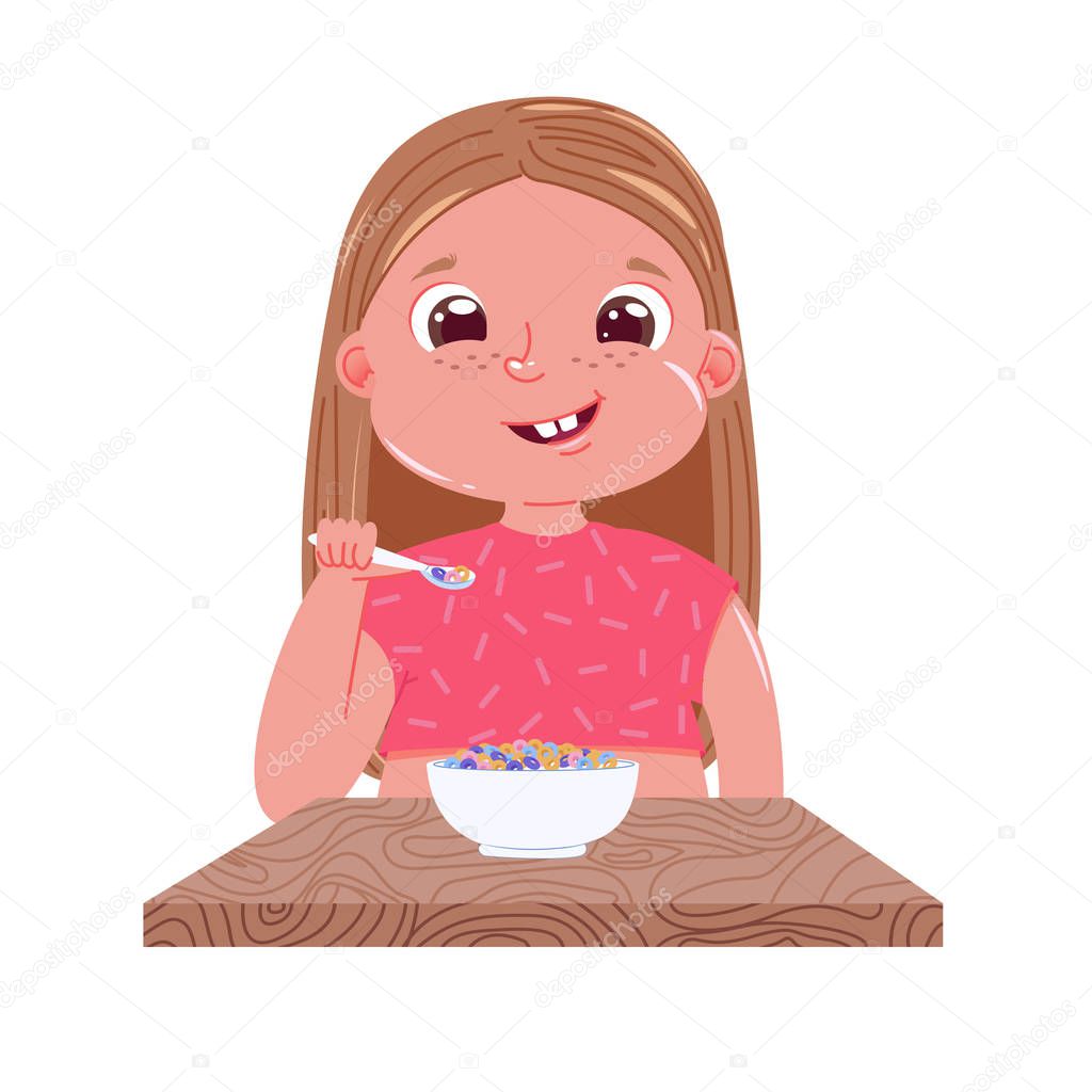 A baby girl eats breakfast in the morning. Sweet dish colourfull corn flakes with milk. Outside the window is a  day and the sun.