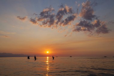 Balıkçılar siluet Bali, Endonezya renkli gün batımında sahilde