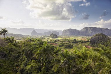 valley in Vinales, Cuba surrounded by mountains with a cloudy sky in the background