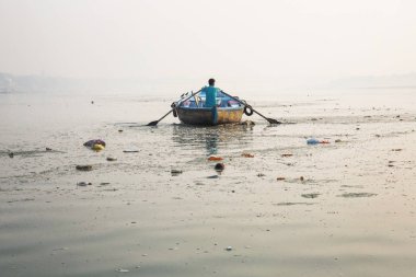 Man rowing a wooden boat crosses the Ganges River in Gosaba, West Bengal, India