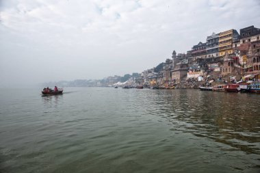 Turistler bakan antik mimari yapıların ve tapınaklar Varanasi, Hindistan'ın kutsal Ganj Nehri üzerinde bir tekne yolculuğu zevk