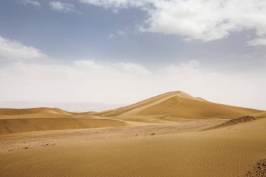 Mavi gökyüzü, taşlar, çalılar ve bulutlar ile Marocco zagora Çöl Manzara