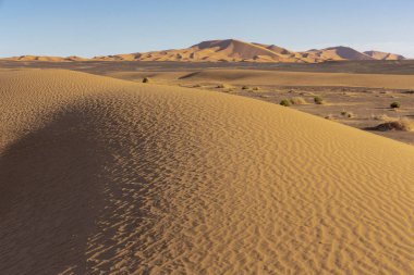 çöl dune arka plan mavi gökyüzü üzerinde. Dağlar ve tepeler renkli kum, Afrika.