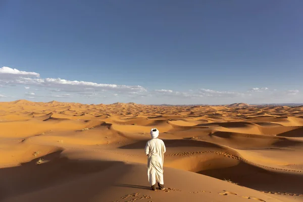 African man waching Brilliant Blue of the Sky Meets the Gold of the Dunes of the african Desert, Sahara