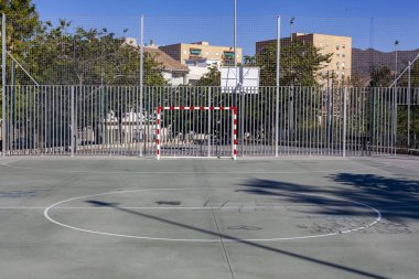 Şehirdeki yüksek evlerin arasında futbol sahası