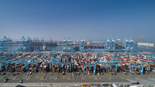 Large harbor cranes loading container ships in the port of Rotte