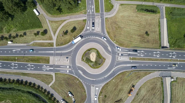 De cima para baixo vista aérea de uma rotunda de tráfego em uma estrada principal em um — Fotografia de Stock