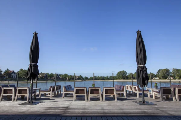 Strandstoel en bruine en witte parasol op de vloer met tropi — Stockfoto