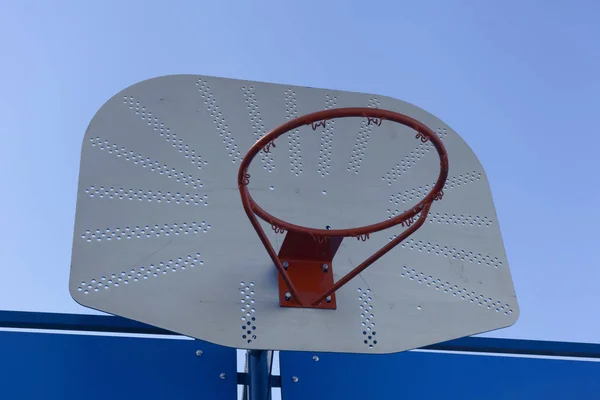 El aro de baloncesto al aire libre contra el cielo azul - baloncesto callejero —  Fotos de Stock