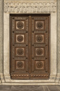 İtalya 'da güzel oymaları olan eski süslü ahşap bir kapı.