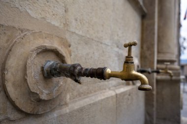 Antik dekoratif musluk. Halka açık su borusunun üzerinde eski stilize edilmiş bronz bir musluk, nüfus için temiz su kaynağı.